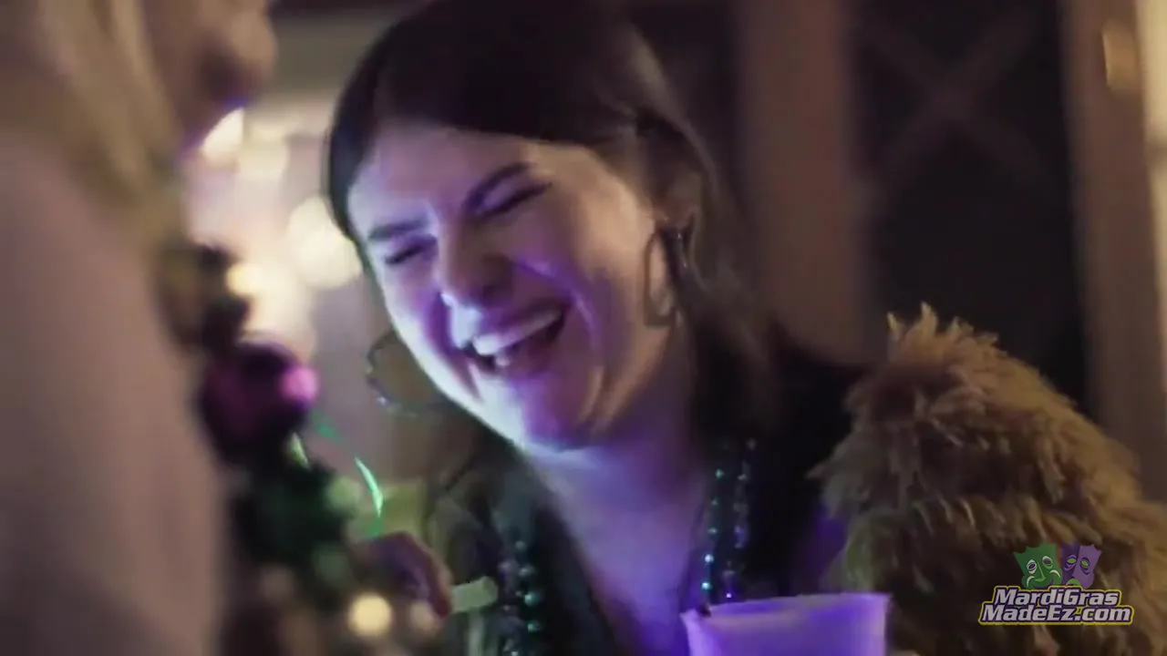 A guest in Mardi Gras beads laughing with friends at a celebration