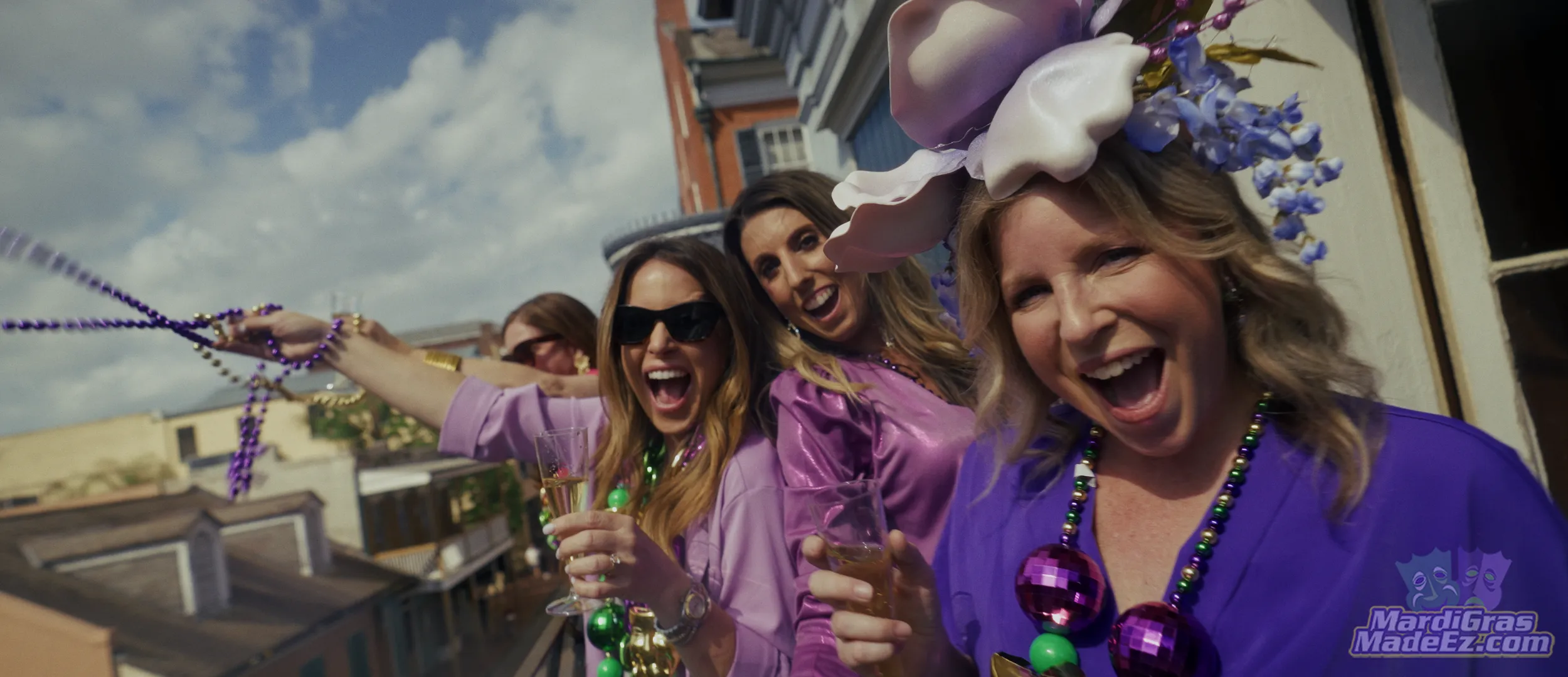 Guests in purple and green celebrating on a balcony